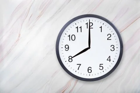 Wall clock show eight o'clock on marble texture. Office clock show 8pm or 8am Stock Photos