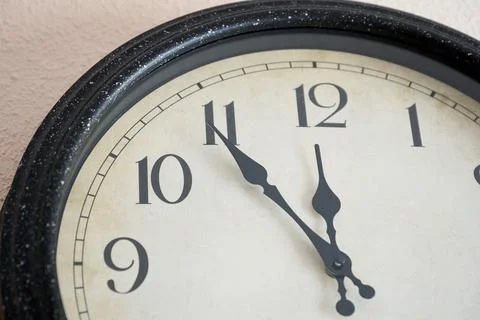 Wall clock showing five to twelve Stock Photos