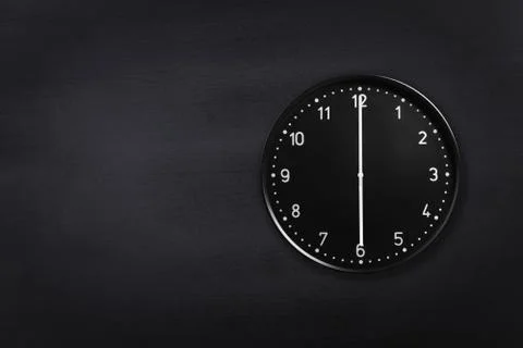 Wall clock showing six o'clock on black chalkboard background. Office clock Stock Photos
