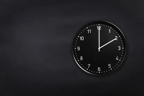Wall clock showing two o'clock on black chalkboard background. Office clock Stock Photos