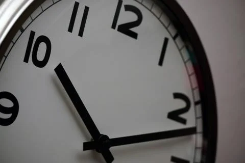 Wall clock with white base and black dials close up view Stock Photos