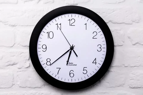 Wall clock on white brick wall Stock Photos