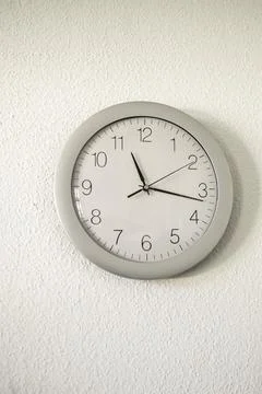 A wall clock on a white wall Stock Photos