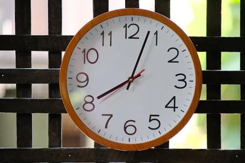 Wall clock on wood background and time concept Stock Photos