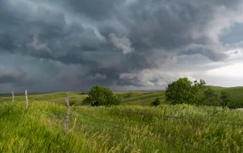 Wall clouds spin below a tornado super-cell hovering and kicking up dust into Stock Photos