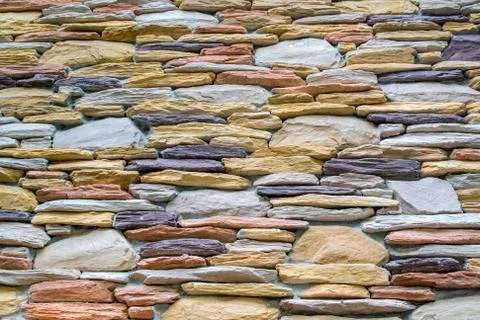 Wall with colorful stone in stack as texture Foto stock