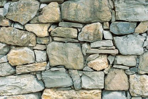 This wall consists of various sizes and shapes of stones arranged closely t.. Stock Photos