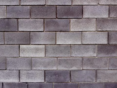 Wall constructed from light grey and dark grey concrete facing tiles. Stone t Stock Photos