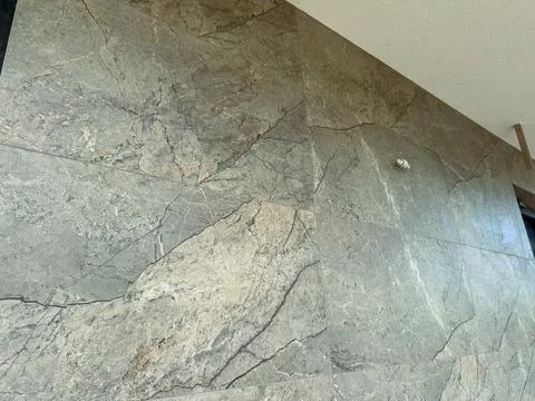Wall covered in grey stone panels in a modern building's interior during da.. Stock Photos