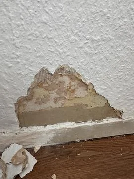 Wall Damage with Visible Layers of Wallpaper and Plaster Stock Photos