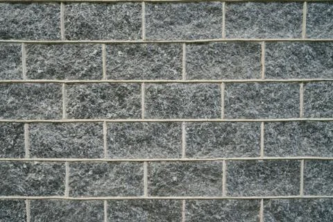 Wall of dark natural stone bricks texture, dark gray surface Stock Photos