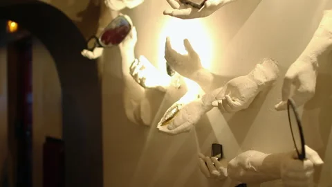 Wall Decor Sculptures of Plaster Hands Holding Mirrors Panning Shot Stock Footage 346602943