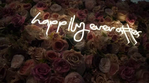 Wall decorated with delicate roses with a "happily ever after" white neon sign o Stock Footage 230912003