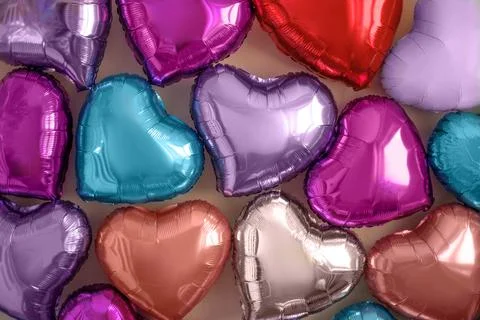 The wall is decorated with multicolored balloons in the shape of heart Stock Photos