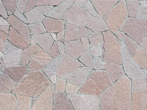 A wall with decorative cladding lined with granite pieces of tiles of different Stock Photos