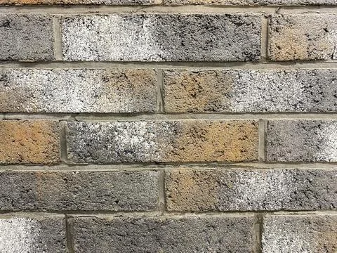 Wall with different shades of bricks shows texture and design Stock Photos