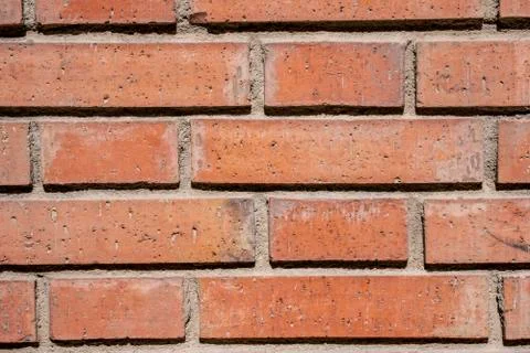 Wall of dirty orange bricks under sunlight. Close-up. Foto stock