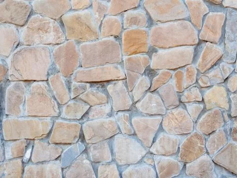 A wall with disorderly stonework. Background texture. Full screen Stock Photos