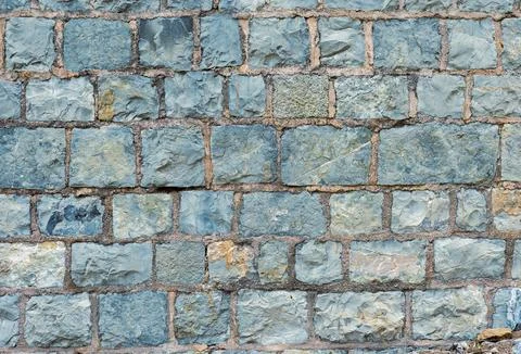 The wall displays a pattern of irregular stones in various shades of gray Stock Photos