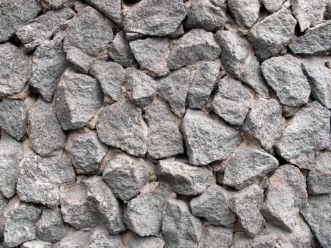 The wall faced with chunks of grey granite Stock Photos