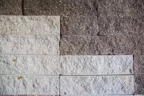 Wall faced with rough rectangular gray stone tiles different shades 写真素材