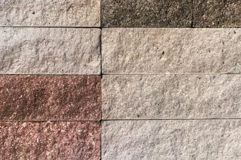 Wall faced with rough rectangular red and gray stone tiles Foto stock