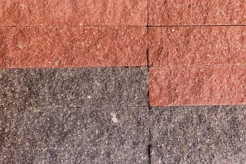 Wall faced with rough rectangular red and gray stone tiles 写真素材