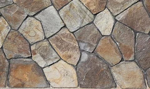 A wall faced with wild steppe flat stone. Stock Photos