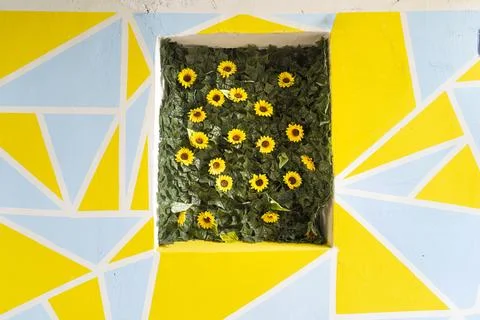 A wall features a geometric pattern of yellow and light blue triangles with.. 스톡 사진