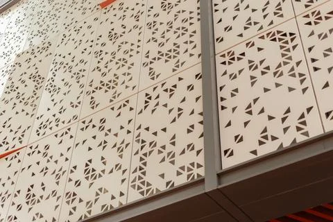 A wall features a pattern of geometric shapes made from cut metal. The uniq.. Stock Photos