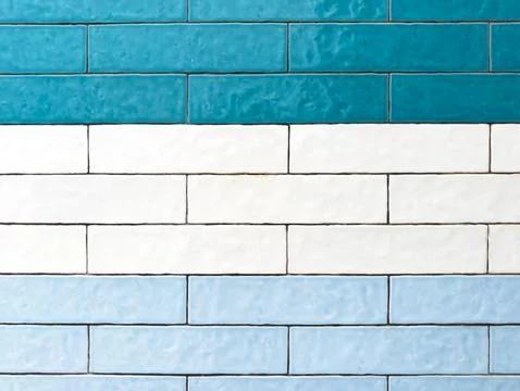 A wall features three distinct horizontal bands of rectangular tiles Stock Photos