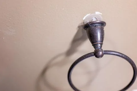 Wall fixture being pulled out of drywall because of a bad installation. Stock Photos