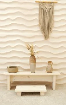 A wall in the form of smooth lines, on which a macrame panel hangs and ther.. Stock Photos