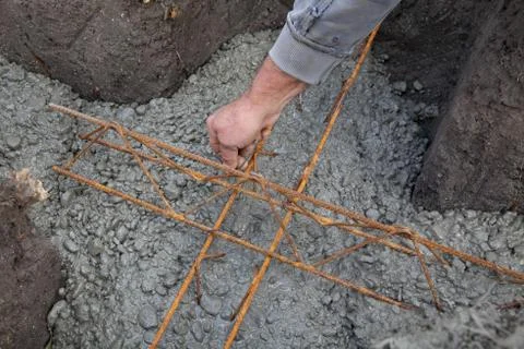 Wall foundation making, worker hand concrete and reinforcement Foto stock