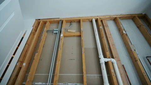 Wall framing with plumbing pipes during house renovation. Construction phase Stock Footage 332185954