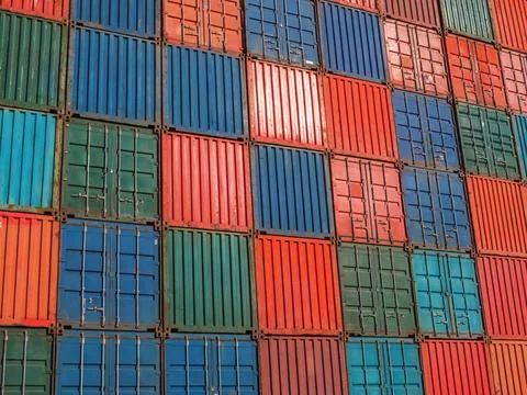 Wall of freight containers of various colors Stock Photos