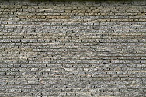 Wall from a granite brick Stock Photos