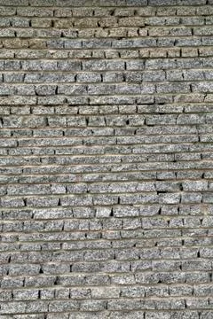 Wall from a granite brick Stock Photos