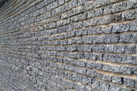 Wall from a granite brick Stock Photos