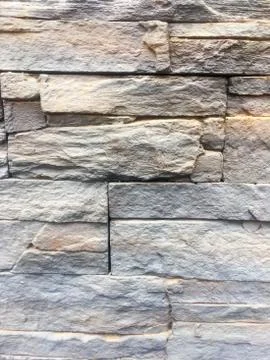 Wall of gray and yellow bricks. Textured stone Background. Stock Photos
