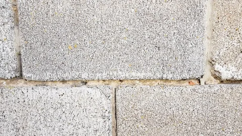 Wall of gray cinder block with sloppy seams. Building's facade. The view is stra Stock Footage 117978525