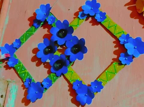 A wall hanging item featuring paper flowers. Stock Photos