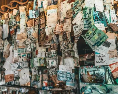 A wall has thousands of different bills from around the world Stock Photos