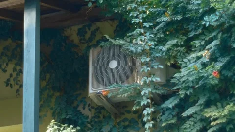 On the wall of house the air conditioner unit is running in the heat Stock Footage 323905770