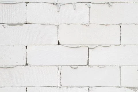 The wall of the house is made of light gray brick with stains of cement Stock Photos