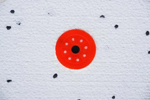 Wall insulation made of pinoplast. Texture with black splashes and red fasteners Stock Photos