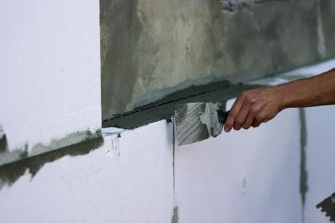 Wall insulation with polystyrene panels, glue application and installation. Stock Photos