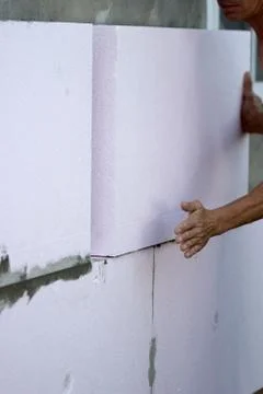 Wall insulation with polystyrene panels, glue application and installation. Stock Photos