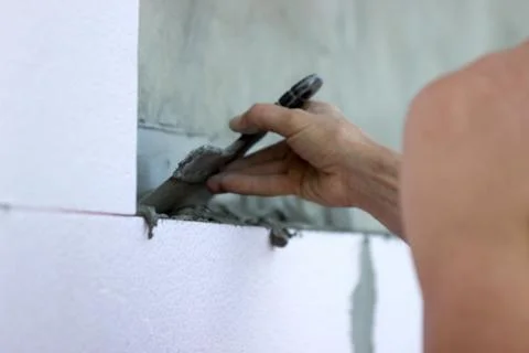 Wall insulation with polystyrene panels, glue application and installation. Stock Photos