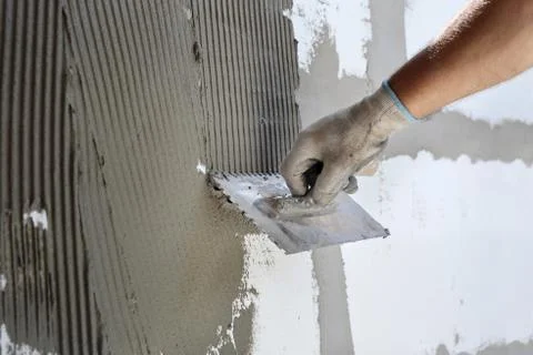 Wall insulation, spreading mortar over styrofoam, polystyrene cover Stock Photos